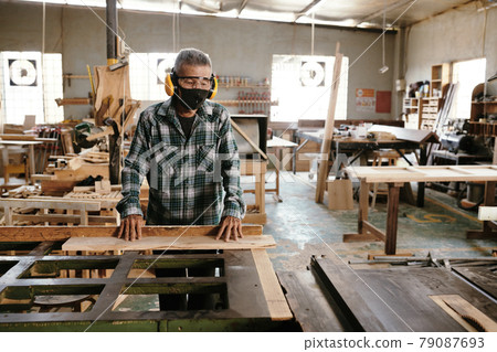 Carpenter Putting Wooden Planks on Workbench 79087693