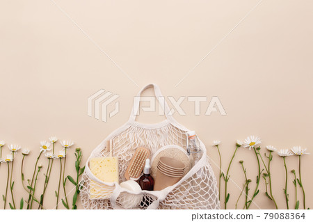 Eco friendly beige flat lay with shopping bag, flowers, bath accessories Eco friendly beige flat lay with shopping bag, flowers, bath accessories 79088364