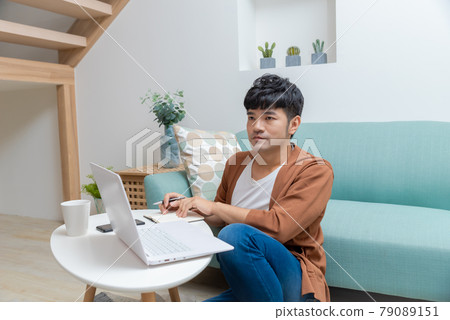 Young man working on computer at home Young man working on computer at home 79089151