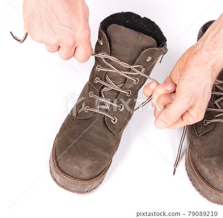 Tying laces of a hiking boot, isolated 79089210