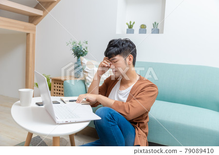 年輕男子在家使用電腦工作 年輕男子在家使用電腦工作 79089410