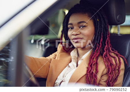 Portrait of positive african american lady inside the car Portrait of positive african american lady inside the car 79090252