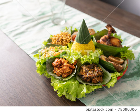 nasi tumpeng. indonesian cuisine yellow rice on banana leaf nasi tumpeng. indonesian cuisine yellow rice on banana leaf 79090300