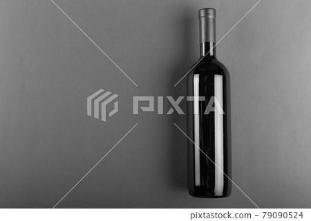 Corked bottle of red wine on a gray background. Alcoholic drink. 79090524