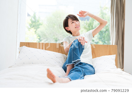 A woman stretching on a bed 79091229