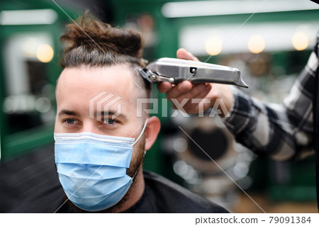 Close-up of man client visiting haidresser in barber shop. 79091384