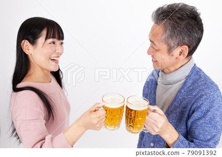 Middle-aged couple toasting with beer Middle-aged couple toasting with beer 79091392