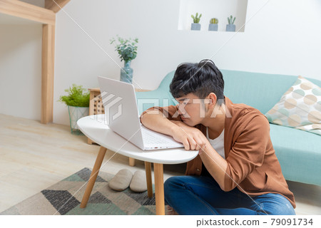 Young man working on computer at home 79091734