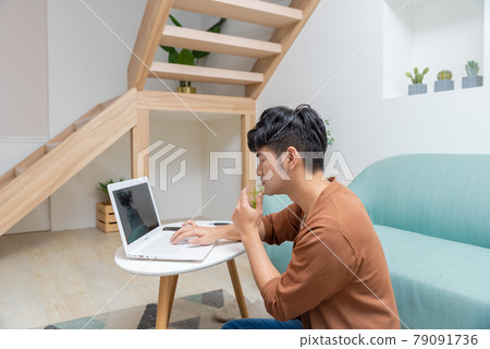 Young man working on computer at home Young man working on computer at home 79091736