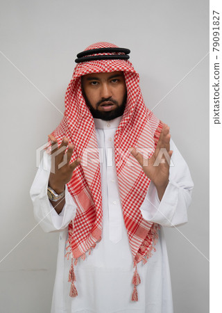 an arabian young man standing looking at the camera with hand gestures while talking an arabian young man standing looking at the camera with hand gestures while talking 79091827