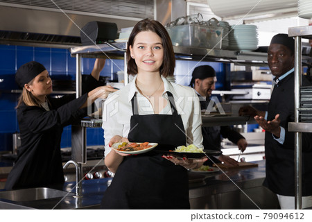 Waitress with dishes in kitchen 79094612