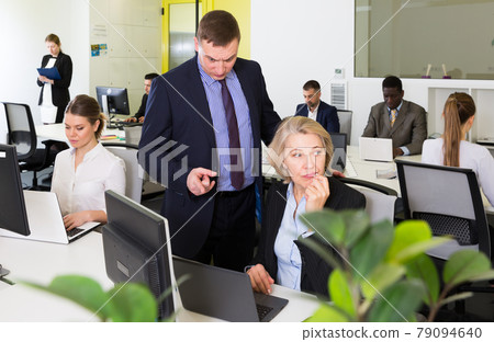 Upset mature woman with dissatisfied manager in coworking space Upset mature woman with dissatisfied manager in coworking space 79094640