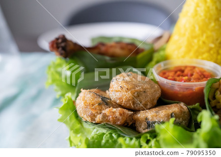nasi tumpeng. indonesian cuisine yellow rice on banana leaf nasi tumpeng. indonesian cuisine yellow rice on banana leaf 79095350