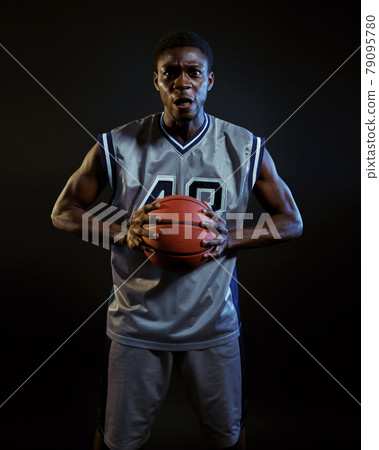 Aggressive basketball player poses with ball Aggressive basketball player poses with ball 79095780