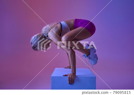 Sportswoman doing balance exercise in studio Sportswoman doing balance exercise in studio 79095815