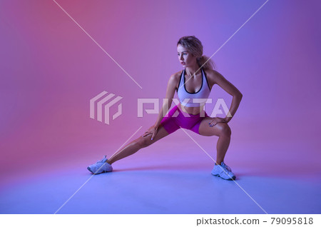 Sportswoman doing stretching exercise in studio Sportswoman doing stretching exercise in studio 79095818