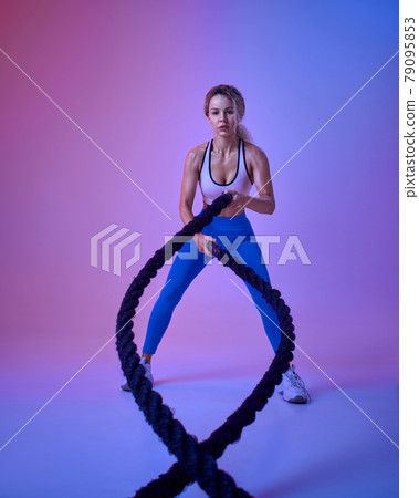Young sportswoman with ropes in studio Young sportswoman with ropes in studio 79095853