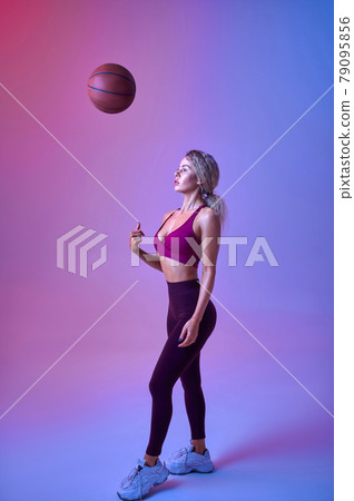 Young sexy sportswoman with ball poses in studio 79095856