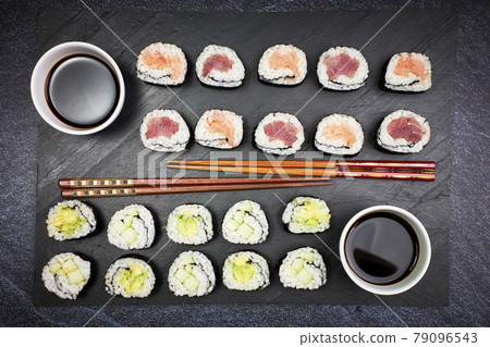 Presentation on a slate of seafood sushi and vegetable sushi with chopsticks. Oriental food Presentation on a slate of seafood sushi and vegetable sushi with chopsticks. Oriental food 79096543