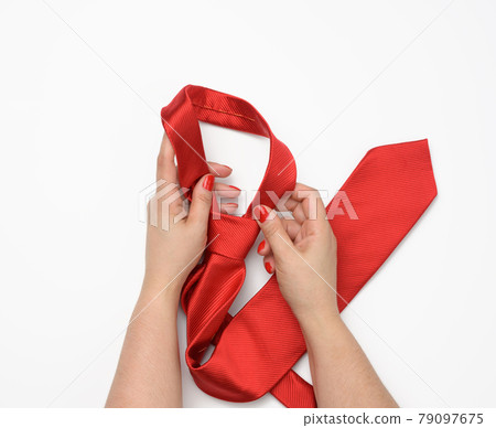 two female hands hold a red silk tie on a white background two female hands hold a red silk tie on a white background 79097675