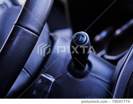 View of the turn signal lever and a part of the steering wheel in the front interior of a car View of the turn signal lever and a part of the steering wheel in the front interior of a car 79097774