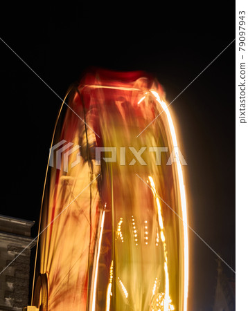 Abstract image of a rotating ferris wheel at night due to motion blur 79097943