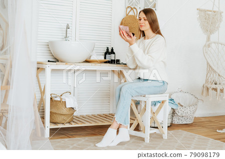 woman sitting near sink and doing makeup woman sitting near sink and doing makeup 79098179