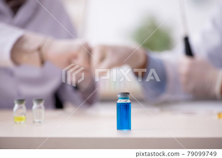 Two male chemists working at the lab during pandemic 79099749