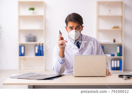 Young male doctor in telemedicine concept during pandemic Young male doctor in telemedicine concept during pandemic 79100012