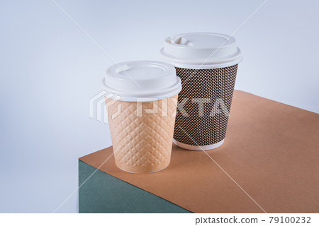 Two craft paper disposable coffee cups. Banner with a white background. 79100232