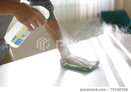 Man disinfecting the table 79100506