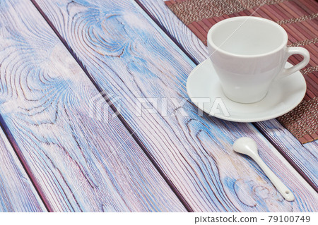 Porcelain cup with saucer and bamboo napkin on wooden background. Porcelain cup with saucer and bamboo napkin on wooden background. 79100749