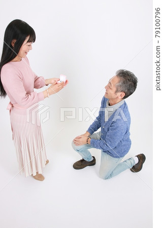 A man who proposes a ring as a gift and a woman who receives it A man who proposes a ring as a gift and a woman who receives it 79100796