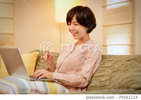 年輕女子在沙發上使用電腦 79101124