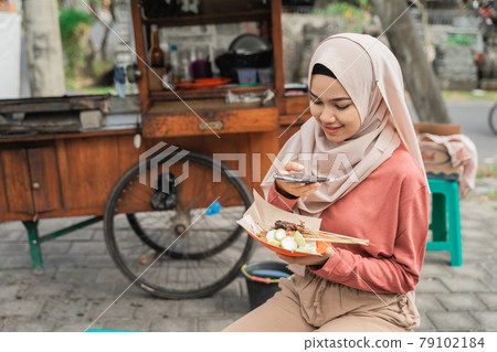 chicken satay buyer taking photo of her food using smart phone chicken satay buyer taking photo of her food using smart phone 79102184