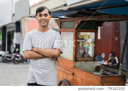man street food seller of chicken satay with food cart selling sate ayam. man street food seller of chicken satay with food cart selling sate ayam. 79102202