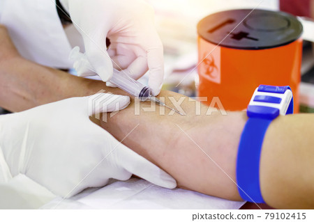 Nurse collecting a blood from patient in hospital 79102415