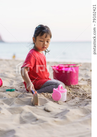 Child playing sand beach, on the beach on summer holidays. Children building a sandcastle at sea 79102421