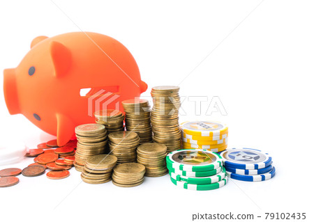 Piggy bank and money coins stack with casino chips on white background. Concept of gambling savings. Piggy bank and money coins stack with casino chips on white background. Concept of gambling savings. 79102435