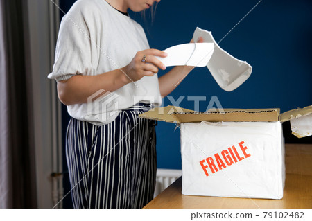 Young woman opening damaged delivery package,online shopping package. Broken fragile plate at home Young woman opening damaged delivery package,online shopping package. Broken fragile plate at home 79102482