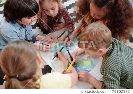 Several diligent kids drawing our planet 79102573