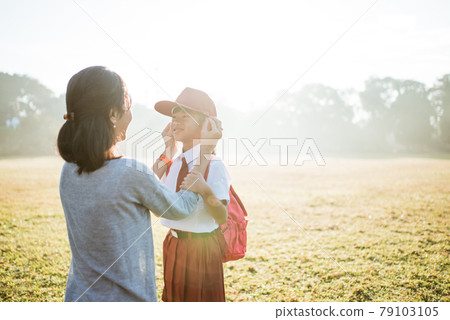 mother fixing her daughter primary school student uniform 79103105