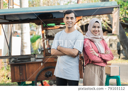 muslim small business entrepreneur with their food cart at the background 79103112