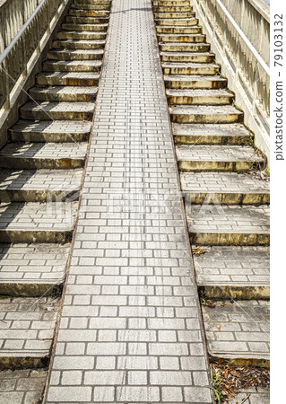 The tile pattern on the slope of the pedestrian bridge is dirty 79103132