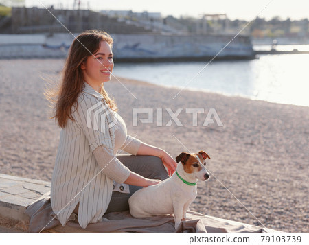 Young woman with her cute Jack Russell Terrier outdoor. Young woman with her cute Jack Russell Terrier outdoor. 79103739