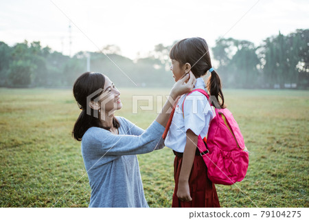 primary school student taken by mother to school in the morning primary school student taken by mother to school in the morning 79104275