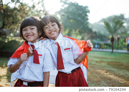 indonesian school student holding flag during independence day. 79104294