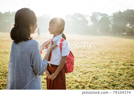 primary school student taken by mother to school in the morning primary school student taken by mother to school in the morning 79104374