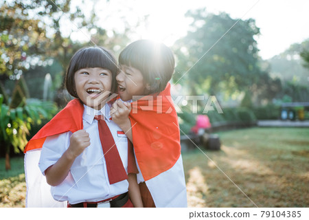 indonesian school student holding flag during independence day. indonesian school student holding flag during independence day. 79104385
