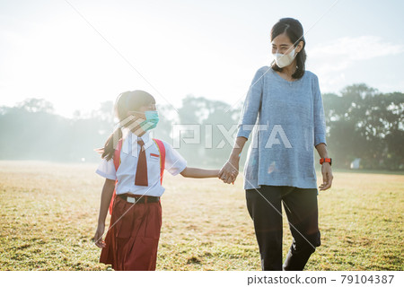mother and her daughter walking together and wear face mask mother and her daughter walking together and wear face mask 79104387